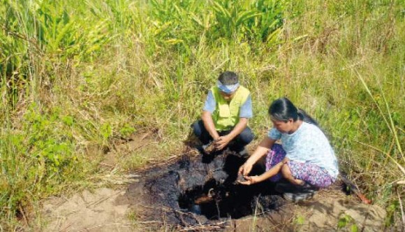 Cuenca del Tigre. Monitor ambiental y madre indígena de la Federación de Comunidades Nativas del Alto Tigre - FECONAT, ante un punto contaminado con petróleo. Año 2012.